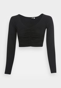 Mustassa pitkähihainen crop-top, jossa on pyöreä pääntie ja rypytystä edessä. Valmistettu sileästä ja joustavasta kankaasta. Istuva muotoilu.