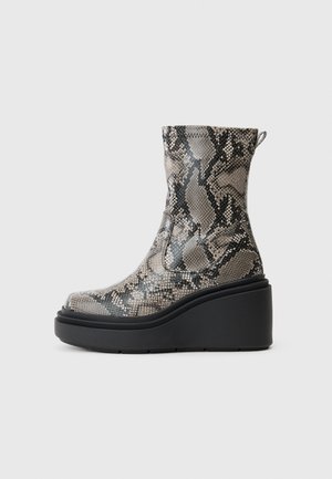 Bottines à talons hauts en motif serpent, présentant des tons gris et noirs, avec une plateforme noire épaisse et un dessus texturé.