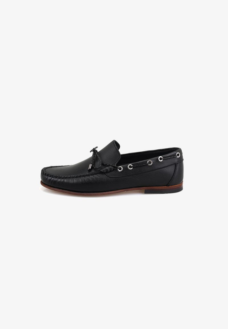 Schwarze Leder-Mokassinschuhe mit runder Zehenform, dekorativer Naht, seitlichen Ösen und einer niederen Profilsohle aus braunem Gummi.