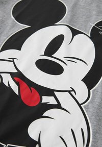 Siva bomba majica iz bombaža z velikim grafičnim prikazom risanega junaka v črno-beli barvi, z rdečim jezikom in značilnimi obrazi.