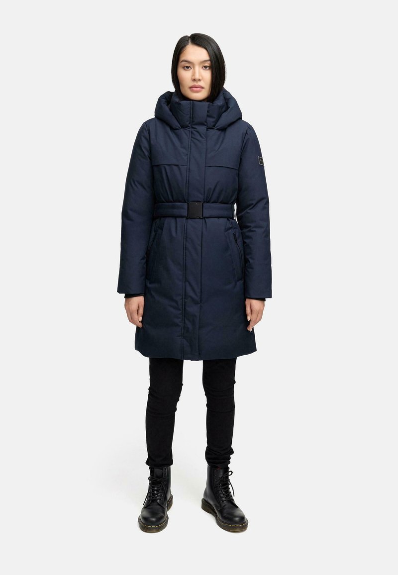 Navy blue puffer coat with a hood and belted waist; features two side pockets and a smooth texture. Black skinny pants and boots complete the outfit.