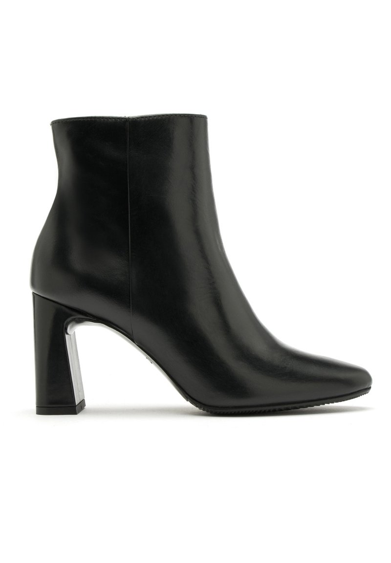 Czarne skórzane botki za kostkę z ostro zakończonym noskiem i słupkowym obcasem. Posiadają gładką teksturę oraz metaliczny akcent na podstawie obcasa.
