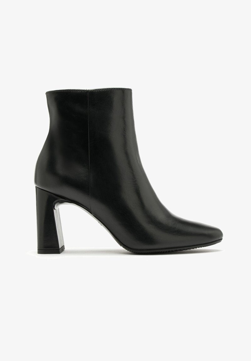 Czarne skórzane botki za kostkę z ostro zakończonym noskiem i słupkowym obcasem. Posiadają gładką teksturę oraz metaliczny akcent na podstawie obcasa.