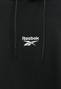 Felpa nera realizzata in morbido tessuto con logo Reebok bianco. Include cordini neri regolabili nel cappuccio e una vestibilità comoda.
