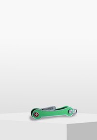 Green multi-tool with a sleek design, featuring a red Swiss cross, metal accents, and a compact shape for portability.