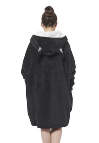 Vestito felpa oversize nero con interno bianco e soffice, dotato di orecchie a punta sul cappuccio e maniche a cuffia.