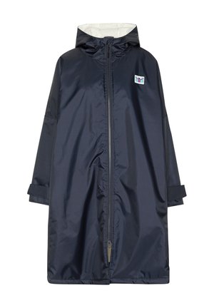 Person, die einen dunklen Kapuzenmantel mit einer grünen und pinken Grafik eines Tauchers und dem Text „Since 1982 Chill See Active Wear“ auf dem Rücken trägt.