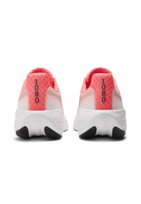 Deux chaussures de course avec une tige en mesh rose, une semelle blanche et un talon noir. Affiche le numéro "1080" à l'arrière près d'un panneau texturé.