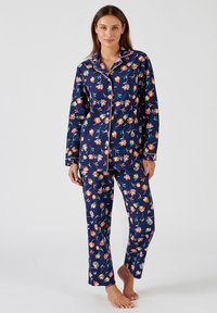 Marine bloemen pyjama's met roze piping. Bevat kleurrijke bloemenpatronen op zowel het bovenstuk als de broek. Zachte textuur, ruime pasvorm.