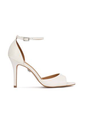 Sandale blanche à talon haut avec bout ouvert, bride à la cheville et boucle, présentée de profil sur un fond blanc.
