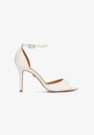 Sandale blanche à talon haut avec bout ouvert, bride à la cheville et boucle, présentée de profil sur un fond blanc.