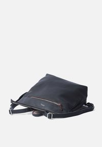 Black leather backpack with a smooth texture, zippered pocket, and adjustable strap. Features red accent stitching and a rectangular shape.
