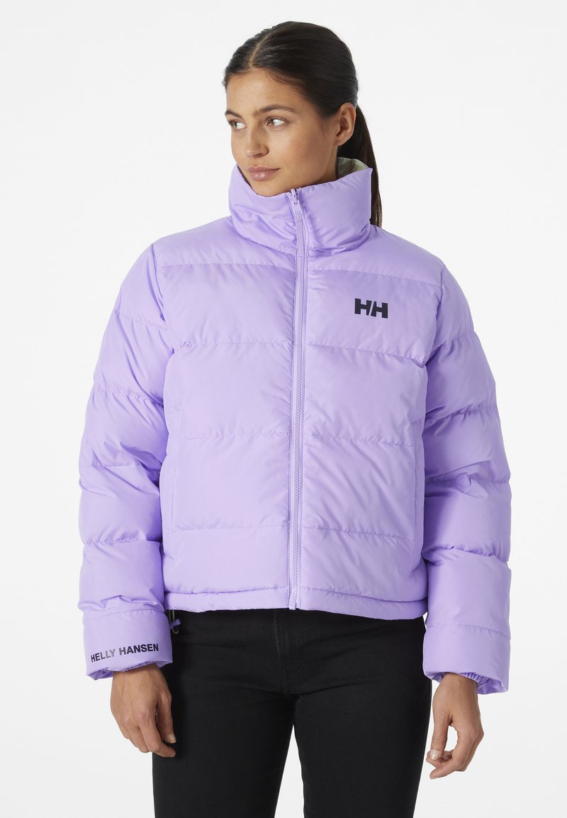 Doudoune violette avec un col haut, fermeture éclair à l'avant et poignets élastiques. Présente le logo noir Helly Hansen sur la poitrine et la manche.