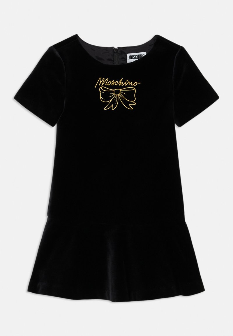 Svart fløyelskjole med korte ermer, rund hals og utsvingt kant. Har gullbrodert logo og sløyfedesign foran.