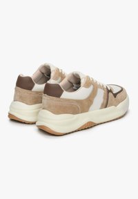 Beige en crèmekleurige sneakers met een mix van suede en leer, een ronde silhouet, witte veters en een gumrubberen buitenzool.
