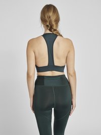 Mörkgrön atletisk kort topp och högmidjade leggings, med racerback-design och ett mjukt, stretchigt material med subtila sömmar.