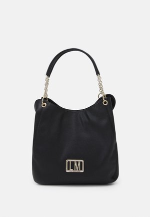 Zwarte leren handtas met een slungelig ontwerp, ketting- en stoffen handgreepaccenten en een gouden logoplaatje aan de voorkant.