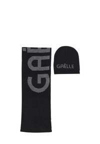 Set di sciarpa e berretto in maglia nera con grande testo grigio "GAËLLE" sulla sciarpa e testo più piccolo sul berretto.