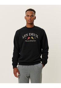 Felpa nera con collo rotondo e polsini a coste. Presenta il logo "LES DEUX" in bianco e accenti colorati. Tessuto morbido, vestibilità rilassata.