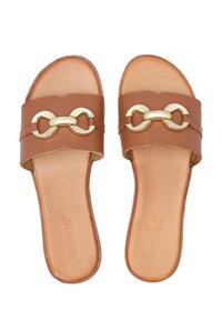 Braune Leder-Sandalen zum Hineinschlüpfen mit einem breiten Riemen und einer goldenen Kettenakzentuierung, flacher Sohle und glatter Textur.