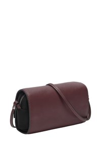 Petit sac bandoulière en cuir bordeaux avec fermeture à rabat et compartiment zippé noir visible sur le côté, isolé sur fond blanc.