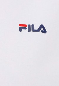 Valkoinen puuvillapaita, jossa on punainen ja sininen FILA-logo. Kangas on sileä ja istuva muotoilu.