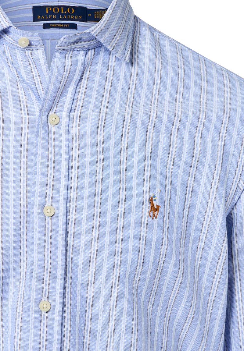 Blauw-wit gestreepte korte mouwen shirt met een button-down kraag; heeft een klein bruin en gouden geborduurd polo speler logo op de borst.