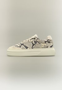 Baskets basses avec une semelle blanche épaisse, des lacets blancs et un motif peau de serpent gris-noir sur la tige, présentées en profil sur un fond gris.