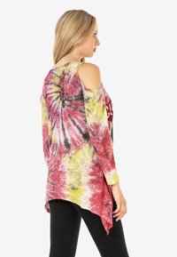 Langärmliges Batik-Oberteil in Rot, Gelb und Schwarz mit Cold-Shoulder-Ausschnitten, asymmetrischem Saum und "Chicago"-Grafik auf der Vorderseite.