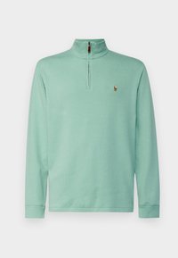 Mintgrön långärmad pullover med kvartdragken, ribbade mudd och en liten broderad logotyp på bröstet. Mjuk tygkvalitet.