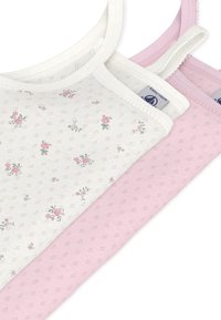 Τρία αμάνικα μπλουζάκια σε λευκό και ροζ. Το λευκό μπλουζάκι έχει ένα λουλουδάτο σχέδιο με μικρά ροζ τριαντάφυλλα, ενώ το ροζ μπλουζάκι έχει μια υφή με μονόχρωμο σχέδιο.