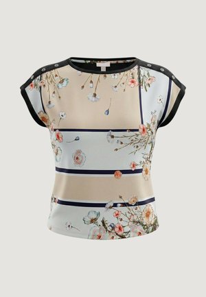 Halenka s krátkým rukávem s béžovými a bílými vodorovnými pruhy, jemnými květinovými vzory, černým lemováním a patentními knoflíky na ramenou.