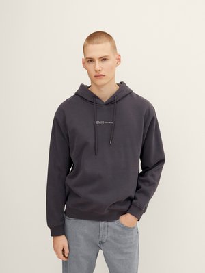Donkergrijze hoodie met verstelbare trekkoorden, voorvak met kangoeroe-stijl en minimale branding. Zachte stof met geribde manchetten en zoom.
