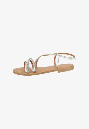 Flat sandals with a light brown sole, featuring silver textured straps and an ankle strap with a gold-tone buckle.