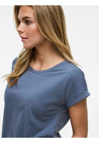 Blå kortärmad t-shirt i bomull med rullade ärmslut. Slät yta, avslappnad passform, inga mönster eller dekorationer.