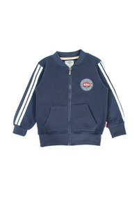 Veste zippée marine avec double rayures blanches sur les manches, deux poches avant, poignets et ourlet côtelés, et un patch logo rond sur la poitrine.