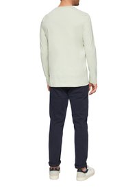 Hellgraues Langarmshirt mit Rundhalsausschnitt, kombiniert mit marineblauen Hosen und weißen Sneakers mit dunklen Akzenten.