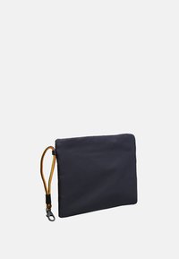 Pochette nera rettangolare con un cinturino da polso intrecciato giallo e nero staccabile e una chiusura nera su uno sfondo bianco.