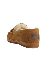 Brune ruskinds-slapper med en blød, faux-fur foring, lav profil, fleksibel gummisål og syet detaljering. Har et logo-patch på bagsiden.