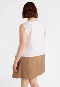 Abito senza maniche con parte superiore bianca e gonna marrone, realizzato in tessuto liscio con una silhouette pulita e orlo arrotondato.