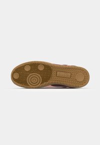 Sole of a brown rubber-soled shoe with circular and diamond tread patterns, featuring the Diadora logo embossed in the center.