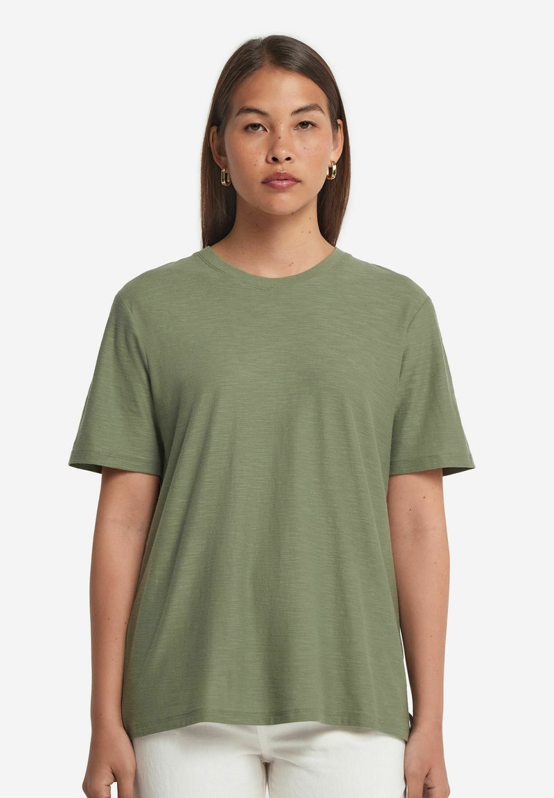 Olivgrön t-shirt i mjukt tyg. Avslappnad passform med korta ärmar och rund halsringning. Har en slät, strukturerad yta.