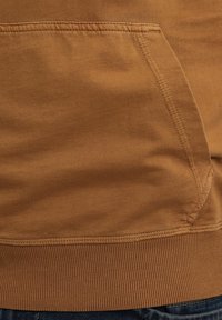 Sudadera de algodón marrón con un bolsillo canguro, con cinturilla y puños de canalé, textura suave y detalles cosidos en las costuras.