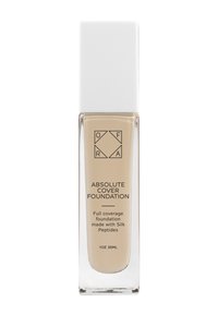 Genomskinlig glasflaska med ett vitt fyrkantigt lock, fylld med en ljus beige flytande foundation, märkt "Absolute Cover Foundation."
