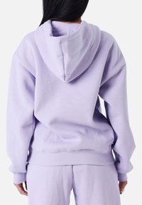 Lavender oversized hoodie met een ontspannen pasvorm, zachte fleece textuur, voorste kangoeroe zak en geribde manchetten. Bevat een gevoerde capuchon.