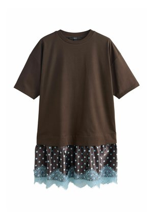 Dunkelbraunes, übergroßes Kurzarmtop, geschichtet über einem braunen Rock mit weißen Punkten und blauer Spitzenbesatz am Saum.