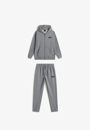 Grå hættetrøje med lynlås med lommer og matchende sweatpants med snoretræk, begge med et lille sort "Off The Wall"-logo.