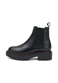 Las botas Chelsea de cuero negro cuentan con paneles elásticos en los laterales para ponerlas y quitarlas fácilmente, una suela de goma gruesa y costuras distintivas alrededor de la base.
