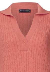 Gestrickter, pfirsichfarbener Pullover mit V-Ausschnitt und Kragen. Ein einziger Knopf am Hals und das Markenetikett "FELIX HARDY" sind sichtbar.