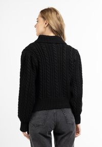 Maglione nero in lavorazione a maglia con colletto alto, caratterizzato da un motivo a treccia e polsini e orlo a coste. Il design include una vestibilità corta.